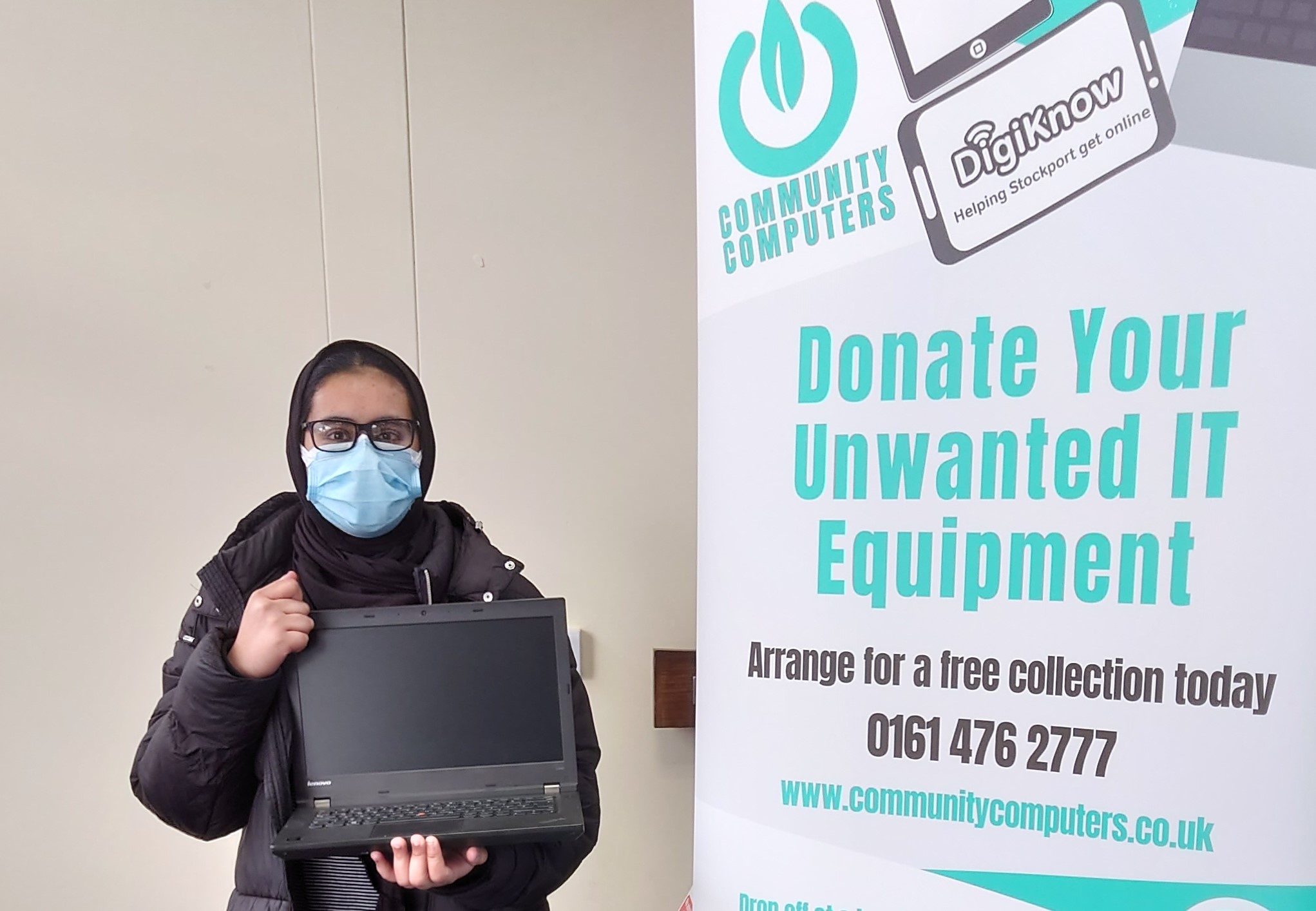 cc photo1 1 Woman wearing a face mask and holding a laptop