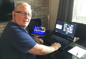 Man sitting at computer smiling at camera