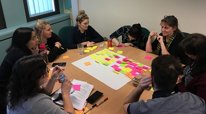 People sitting round table with post-it notes