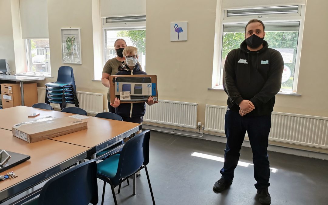 Starting Point's James with residents receiving laptops from library