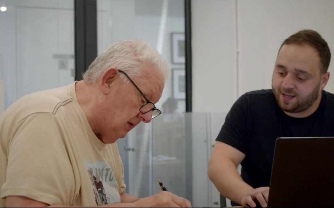 2 men looking at a tablet computer