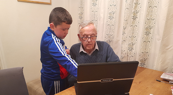 Grandad and grandson looking at a computer