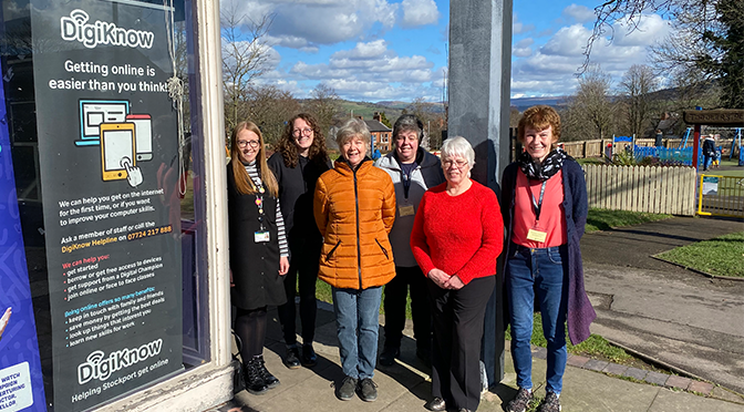 Six women next to a sign promoting DigiKnow support