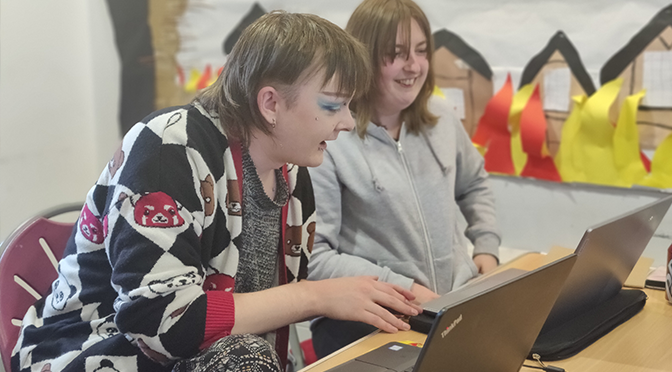 Two young people looking at computers