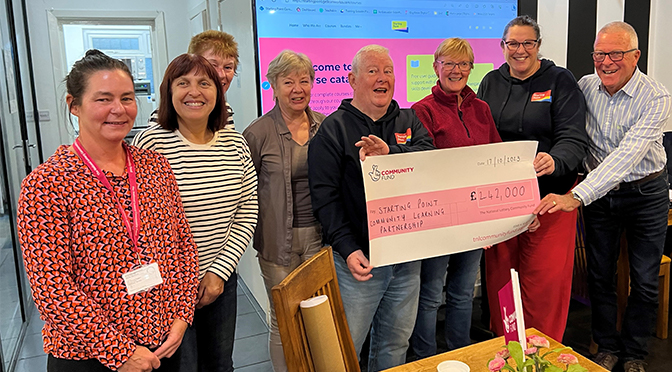 A group of people holding a giant cheque