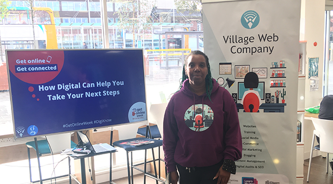 Blog author standing next to a banner with Village web company and a Get Online week sign